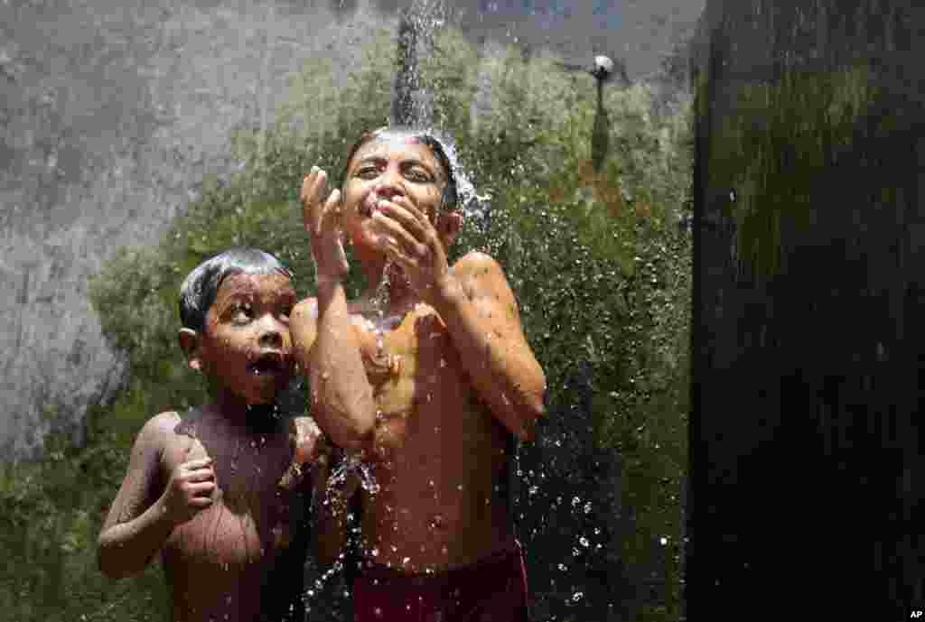 Dua anak Bangladesh mandi di kamp Mohammadpur Geneva, salah satu kamp pengungsi terbesar di Kota Dhaka.