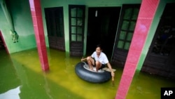 Nguyen Van Bon paddles a rubber tire tube at his flooded house in Chuong My district, Hanoi, Vietnam, July 31, 2018.