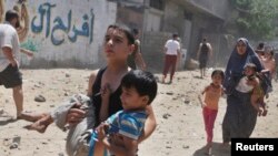 7月9日加沙城中一所房屋遭到以色列战机空袭后巴勒斯坦人逃离险境