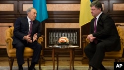 Kazakh President Nursultan Nazarbayev (L) speaks to Ukrainian President Petro Poroshenko during their meeting in Kyiv, Dec. 22, 2014.