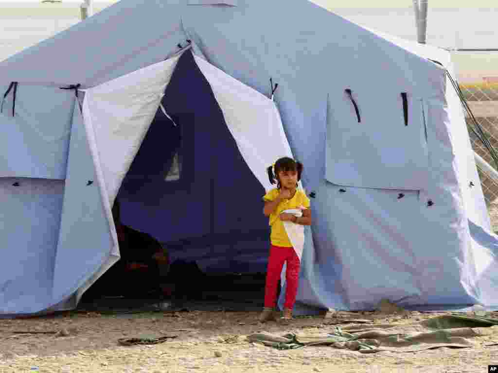 A refugee from Mosul stands outside her family&#39;s tent at Khazir refugee camp outside Irbil, Iraq, June 11, 2014.