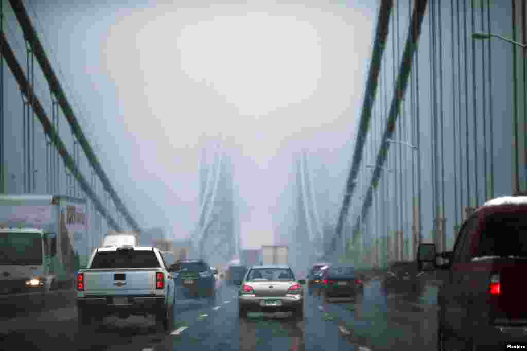 FILE - Cars make their way through the George Washington bridge in New York City. New York and some other parts of the U.S. Northeast could be covered with more than 60 centimeters of snow in the coming days.