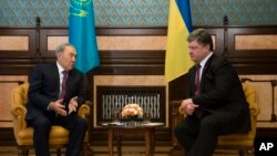 Presiden Kazakstan Nursultan Nazarbayev (kiri) berbicara kepada Presiden Ukraina Petro Poroshenko dalam pertemuan mereka di Kyiv, Ukraina, 22/12/2014.