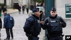 Policemen guard the entrance of the Pere Lachaise cemetery during the funeral of French cartoonist Georges Wolinski, in Paris, Thursday, Jan. 15, 2015. 