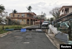 Unos tenis cuelgan de cables caídos tras paso del huracán María en el municipio de Guaynabo, Puerto Rico, el 1 de octubre de 2017.