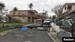 Sneakers hang from downed wires in the wake of Hurricane Maria in the Vietnam section of Guaynabo, Puerto Rico, Oct. 1, 2017. 