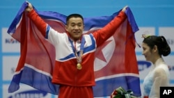 지난 20일 남자 역기 56kg급 경기에서 북한의 엄윤철 선수가 세계 신기록과 아시아 신기록을 세우며 금메달을 목에 걸었다.