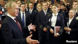 Russian President Vladimir Putin (L) meets with students while visiting the National Mineral Resources University in St. Petersburg, Jan. 26, 2015.