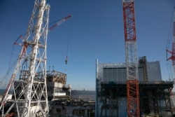 In this Feb. 12, 2020, photo, the Unit 1 and 2 reactor buildings, damaged by the 2011 earthquake and tsunami, are seen at the Fukushima Dai-ichi nuclear power plant in Okuma, Fukushima Prefecture, Japan.