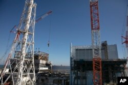 In this Feb. 12, 2020, photo, the Unit 1 and 2 reactor buildings, damaged by the 2011 earthquake and tsunami, are seen at the Fukushima Dai-ichi nuclear power plant in Okuma, Fukushima Prefecture, Japan.