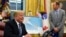 President Donald Trump, left, talks about Hurricane Florence during a briefing in the Oval Office of the White House in Washington, Sept. 11, 2018, as FEMA Administrator Brock Long listens at right. 