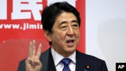 24일 일본 도쿄에서 아베 신조 일본 총리가 자민당 총재 재선 기자회견을 하고 있다. 아베노믹스의 새로운 3대 정책으로 제시하며 손가락을 보이고 있다.