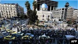 People gather for a rally called for by Syrian activists and civil society representatives "to mourn for the civilian and security personnel casualties", at al-Marjeh square in Damascus on March 9, 2025. 