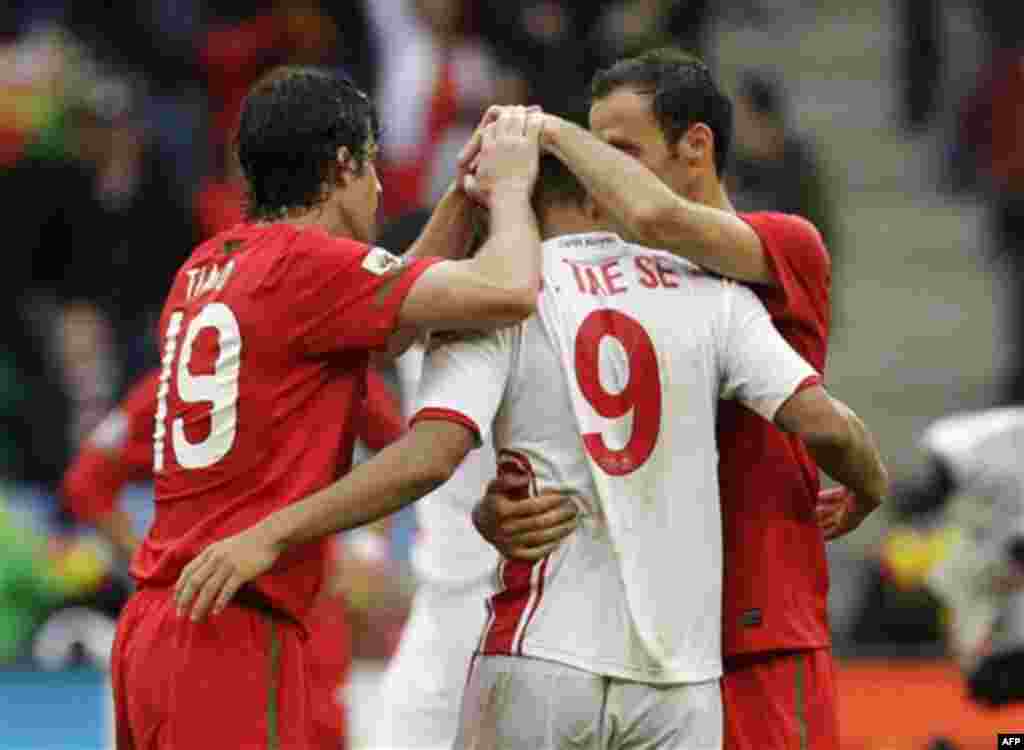 North Korea's Jong Tae Se, center, is embraced by Portugal's Tiago, left, and Portugal's Ricardo Carvalho, right, at the end of the World Cup group G soccer match between Portugal and North Korea in Cape Town, South Africa, Monday, June 21, 2010. Portugal