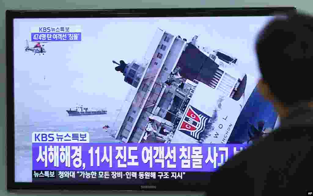 A man watches a TV news program showing a sinking passenger ship, at Seoul Railway Station in Seoul, South Korea, Wednesday, April 16, 2014.