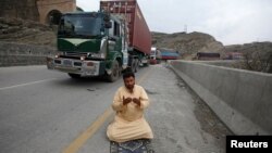 Seorang sopir truk sedang salat dekat kendaraannya setelah pembukaan perbatasan Pakistan-Afghanistan Torkham, di Landi Kotal, Pakistan, 21 Maret 2017.