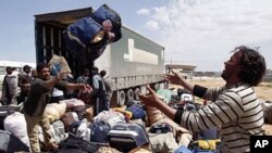 An evacuee reaches out for his luggage at the Libyan Red Crescent camp in Benghazi Apr 16 2011