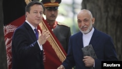 Britain's Prime Minister David Cameron (L) attends a news conference with Afghan President Hamid Karzai at the Presidential Palace in Kabul, Afghanistan, July 19, 2012.