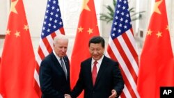 រូបឯកសារ៖ ប្រធានាធិបតី​ចិន លោក Xi Jinping (ស្ដាំ) ចាប់​ដៃ​ជាមួយនឹង​លោក Joe Biden ដែល​កាល​ពី​ពេល​នោះ​គឺ​ជាអនុប្រធានាធិបតី​សហរដ្ឋ​អាមេរិក​នៅឡើយ ទីក្រុង​ប៉េកាំង ប្រទេស​ចិន ថ្ងៃទី៤ ខែធ្នូ ឆ្នាំ២០១៣។