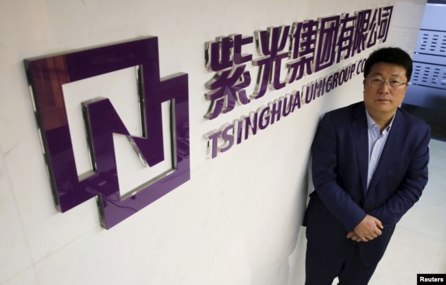 资料照:紫光集团董事长赵伟国站在该集团北京办公室的标识前。(2015年11月15日)