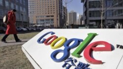 A woman walks past the logo of Google in front of its headquarters in Beijing January 12, 2011