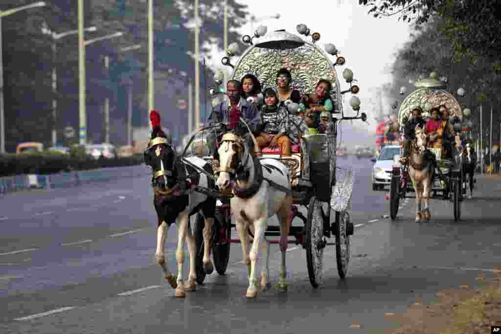 Indian families enjoy a ride on decorated horse carts on the first day of the new year, Kolkata, India, Jan. 1, 2014. 
