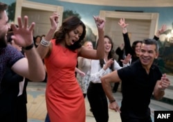 First lady Michelle Obama dances to Gloria Estefan's "Conga" in the Diplomatic Room of the White House in Washington, Nov. 16, 2015, during a Broadway at the White House event for high school students involved in performing arts programs.
