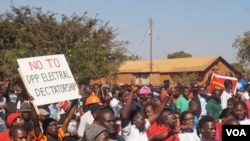 FILE - Demonstrators march along a street protesting May election results during a rally in Malawi's capital Lilongwe. Despite the coronavirus spread, a re-run of the vote is now scheduled for July. (Lameck Masina/VOA)