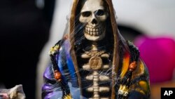 Los vendedores exhiben estatuas ornamentadas de "La Santa Muerte", en el barrio de Tepito de la Ciudad de México, el martes 1 de noviembre de 2022. 