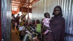 Seorang perempuan tampak menggendong anaknya saat berada di kamp pengungsi Zamzam di Sudan, yang terletak di dekat wilayah El Fasher, di Darfur Utara, pada Januari 2024. (Foto: MSF/Mohamed Zakaria/Handout via Reuters)