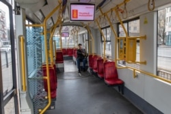 FILE - A man sits inside an empty tram amid an outbreak of the coronavirus, in Warsaw, Poland, March 14, 2020.