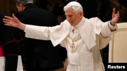 Pope Benedict XVI opens his arms in greetings as he arrives to lead his Wednesday general audience in Paul VI hall at the Vatican, February 13, 2013.