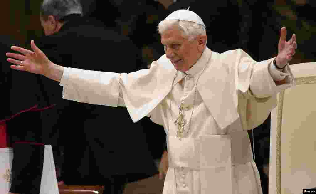 Pope Benedict XVI opens his arms in greetings as he arrives to lead his Wednesday general audience in Paul VI hall at the Vatican Feb. 13, 2013.