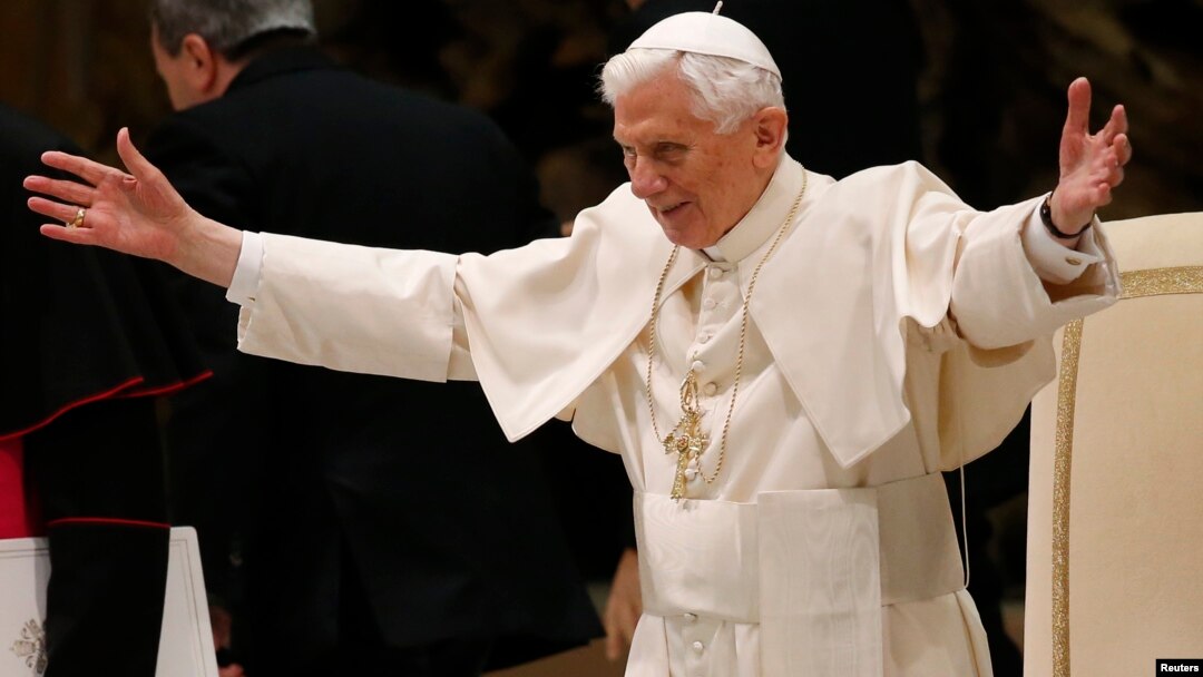 Pope Benedict XVI opens his arms in greetings as he arrives to lead his Wednesday general audience in Paul VI hall at the Vatican, February 13, 2013.