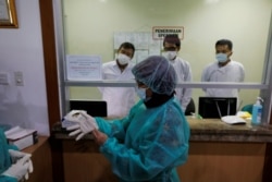 Para wartawan mengenakan baju pelindung saat kunjungan media ke Laboratorium Penelitian Penyakit Infeksi, Kementerian Kesehatan, setelah merebaknya wabah virus corona di China, Jakarta, 11 Februari 2020. (Foto: Reuters)