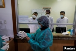 Para wartawan mengenakan baju pelindug saat kunjungan media ke Laboratorium Penelitian Penyakit Infeksi, Kementerian Kesehatan, 11 Februari 2020. (Foto: Reuters)