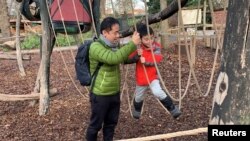 American student Xiyue Wang plays with his six-year-old son at an undisclosed location in Germany after they were reunited following Wang's release as part of a prisoner swap with Iran in early December 2019.