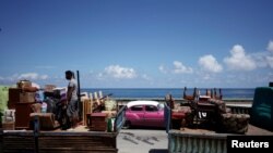 A man loads a truck with furniture to be relocated prior to the anticipated arrival of Tropical Storm Elsa, in Havana, Cuba, July 4, 2021.