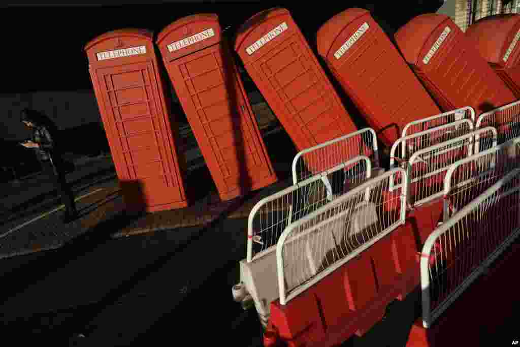 영국 런던 남서부 킹스턴어폰템스에 있는 영국 작가 데이비드 마크의 1989년 작품 &#39;아웃 오브 오더(Out of Order)&#39;에 햇살이 비추고 있다. 붉은 공중전화 부스 12개를 쓰러져가는 모습으로 설치했다.