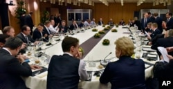 British Prime Minister David Cameron, center left, talks during the round table meeting of European Union heads of state and government at an EU summit in Brussels, Feb. 19, 2016.