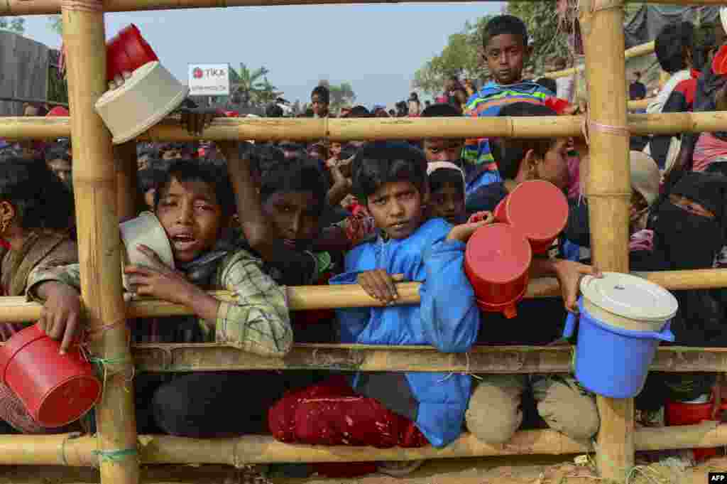 Rohingya Muslim refugees wait for food aid at Thankhali refugee camp in Bangladesh's Ukhia district.