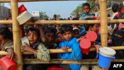 Rohingya Muslim refugees wait for food aid at Thankhali refugee camp in Bangladesh's Ukhia district.