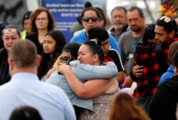 Relatives hug as they wait for the rescue mission, following the White Island volcano eruption in Whakatane, New Zealand, Dec. 13, 2019.