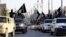 FILE - Islamic State fighters parade on military vehicles along the streets of Syria's northern Raqqa province.