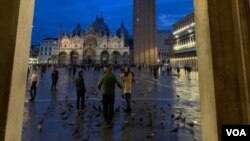 FILE - Tourists are seen in Venice's iconic St. Mark's Square after November floodwaters receded. (Sabina Castelfranco/VOA)