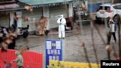 Seorang petugas memeriksa sebuah pasar seafood yang ditutup di kota Wuhan, provinsi Hubei, China.