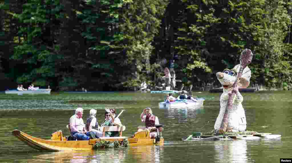 A boat carrying a ratatouille figure, made out of daffodil flowers, takes part in a parade at the Narzissenfest (Daffodil Festival) along Grundlsee lake in the village of Bad Aussee, Austria.