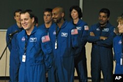 FILE - Ricky Arnold, left, speaks after being sworn in during a ceremony inside the old Apollo Mission Control room at Johnson Space Center in Houston, Texas, June 14, 2004.