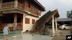 A woman looks at a partly damaged house following an earthquake in Chiang Rai province, northern Thailand, on May 5, 2014. 