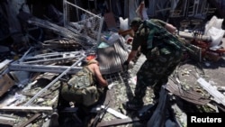 Armed pro-Russian separatists inspect wreckage near a damaged building following what locals say was a recent airstrike by Ukrainian forces in Donetsk, Aug. 6, 2014. 